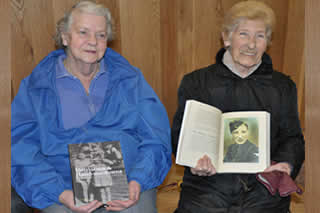 Harriet Donnelly (right) shows Margaret Taylor (left) a photo of her brother John Donnelly ( published in the book). 